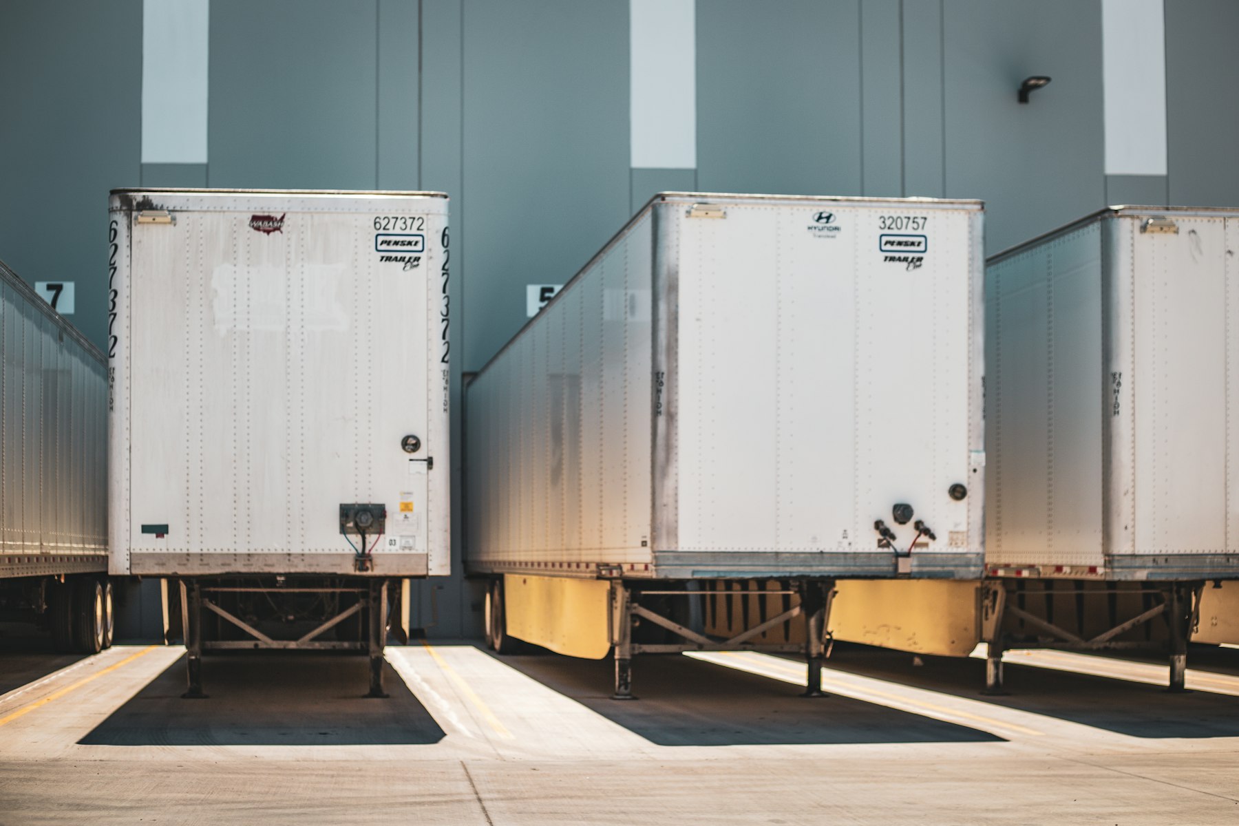 Row of white trailers backed into dock doors at a distribution center
