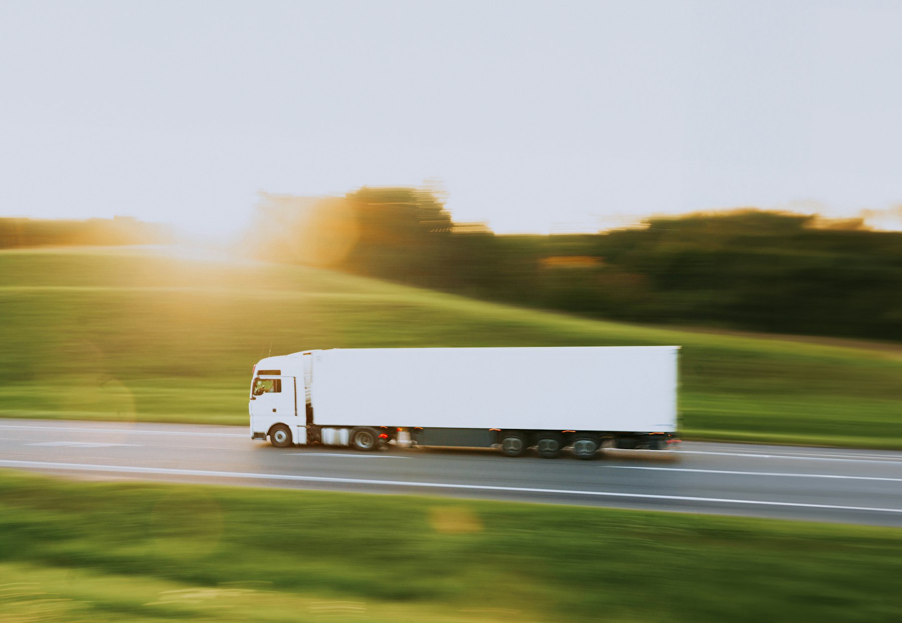 White dry van semi trailer moving down an open American highway