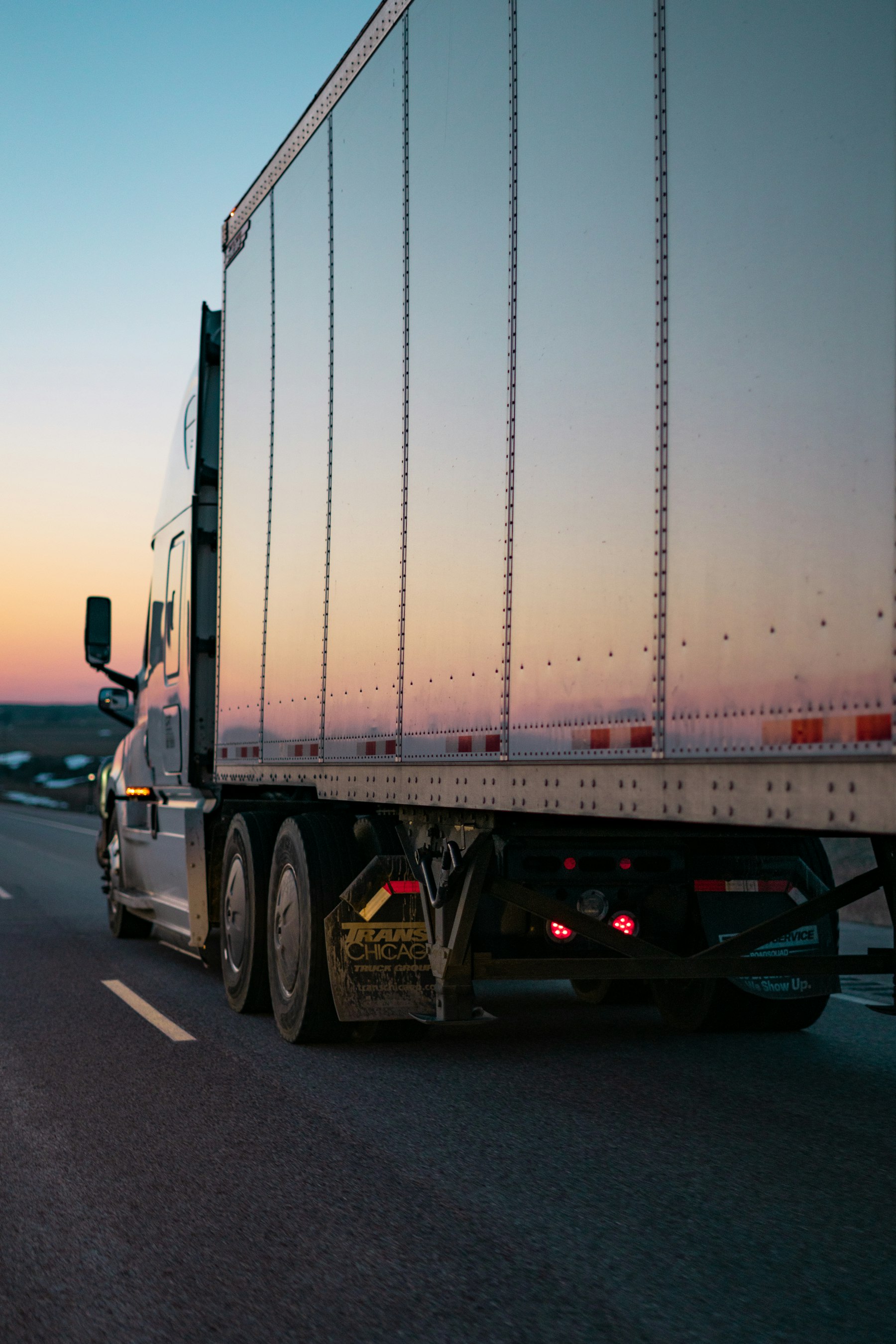 White dry van trailer at dusk beside a highway